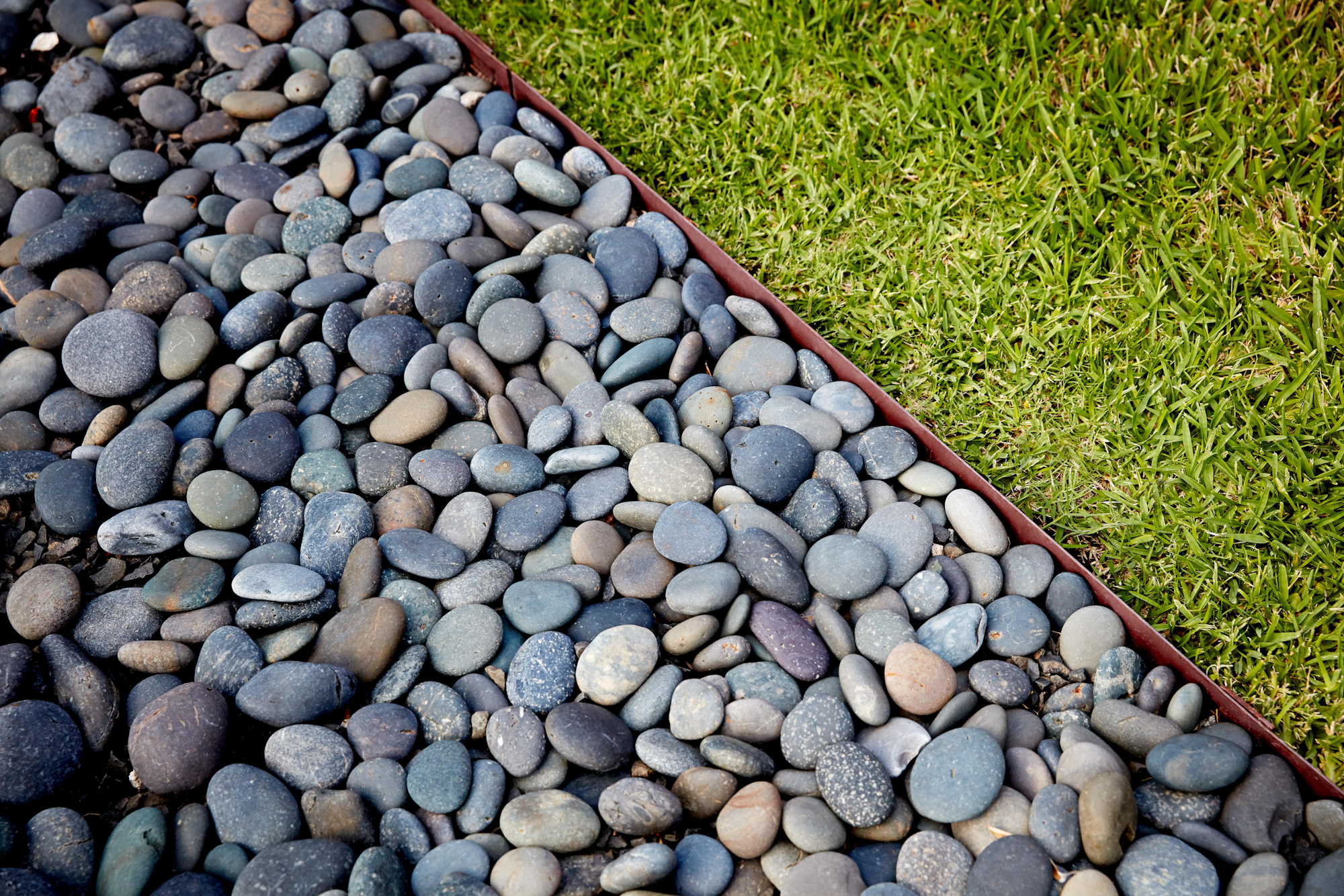 metal garden edging between lawn and pebbles